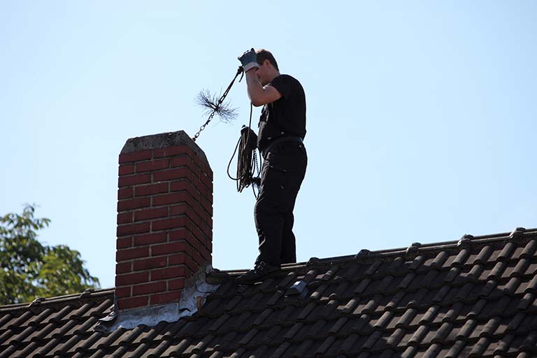 Chimney sweep inserting a brush